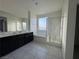 Bright bathroom with double sinks, tiled floors, separate shower stall and soaking tub under window at 4076 Topaz Hills Dr, North Las Vegas, NV 89032