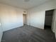 A carpeted bedroom with a window and doorway featuring a view of the closet and hallway beyond at 4076 Topaz Hills Dr, North Las Vegas, NV 89032
