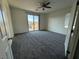 Bright bedroom features plush carpet, ceiling fan, and access to balcony at 4076 Topaz Hills Dr, North Las Vegas, NV 89032