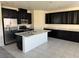 Modern kitchen with black cabinets, white countertops and backsplash, and stainless steel appliances at 4076 Topaz Hills Dr, North Las Vegas, NV 89032