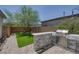 Cozy backyard with artificial grass, stone grill station, and privacy fence at 412 Gracious Way, Henderson, NV 89011