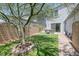 Green backyard with artificial grass, large tree, stone features, and block wall at 412 Gracious Way, Henderson, NV 89011
