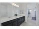 Elegant bathroom features a double sink vanity, sleek countertops, and a view into the main bedroom at 412 Gracious Way, Henderson, NV 89011