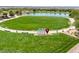 Expansive community park with lush green lawn, paved walking paths, landscaping and neighborhood signage at 412 Gracious Way, Henderson, NV 89011