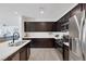 Contemporary kitchen with sleek stainless steel appliances, dark wood cabinets, and a stylish island with a sink at 412 Gracious Way, Henderson, NV 89011