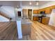 Open concept kitchen with an eat-in kitchen island featuring wood-look floors and stainless steel appliances at 4126 Jessica Marie St, North Las Vegas, NV 89032
