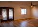 Spacious living room with wood-look flooring, ceiling fan, and glass doors to the backyard at 4126 Jessica Marie St, North Las Vegas, NV 89032
