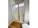 Bathroom glass enclosed shower stall with wood-look flooring and white baseboards at 4126 Jessica Marie St, North Las Vegas, NV 89032