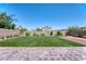Backyard featuring artificial turf, trees, and brick-paved patio at 4206 Topaz Hills Dr, North Las Vegas, NV 89032