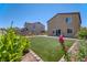 Backyard view with artificial turf and mature landscaping at 4206 Topaz Hills Dr, North Las Vegas, NV 89032