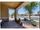 Covered front porch featuring brick flooring, a view of the street, and desert landscaping at 4206 Topaz Hills Dr, North Las Vegas, NV 89032