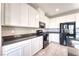 Modern kitchen with white cabinets, black appliances and countertops, and stylish tiled flooring at 4206 Topaz Hills Dr, North Las Vegas, NV 89032
