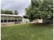 View of the backyard showing a large lawn, mature tree, and the back of the home at 4444 Denia Cir, Las Vegas, NV 89108
