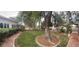 Beautifully landscaped front yard with mature trees, brick walkway, and well-maintained hedges at 4444 Denia Cir, Las Vegas, NV 89108