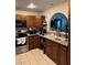 Cozy kitchen featuring tile flooring, wood cabinets, and stainless steel appliances at 4444 Denia Cir, Las Vegas, NV 89108
