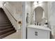 Bathroom features a white vanity with marble countertop, oval mirror, and access to stairs at 5234 Tulip Hill Ave, Las Vegas, NV 89141