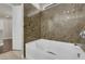 Bathroom featuring a white tub with matching tile and chrome fixtures with a view of the entry door at 5234 Tulip Hill Ave, Las Vegas, NV 89141
