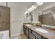 Bathroom featuring double sinks with dark wood cabinetry and granite countertops and a decorative tiled shower at 5234 Tulip Hill Ave, Las Vegas, NV 89141