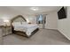 Bedroom with carpeting, large bed, side tables, and wall-mounted TV at 5234 Tulip Hill Ave, Las Vegas, NV 89141