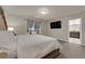 Bedroom with carpeting, large bed, side tables, wall-mounted TV, and ensuite bathroom at 5234 Tulip Hill Ave, Las Vegas, NV 89141
