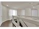 Bright hallway featuring hardwood floors, neutral walls, and a staircase leading to the lower level at 5234 Tulip Hill Ave, Las Vegas, NV 89141