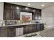 Kitchen with granite countertops, stainless steel appliances, and dark wood cabinets and tiled backsplash at 5234 Tulip Hill Ave, Las Vegas, NV 89141