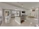 Open-concept kitchen and living area with granite island, tiled floors, and sliding glass doors to backyard at 5234 Tulip Hill Ave, Las Vegas, NV 89141