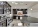 Well-equipped kitchen with stainless steel appliances, granite countertops, and dark wood cabinets at 5234 Tulip Hill Ave, Las Vegas, NV 89141