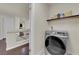 Well-equipped laundry room including a front-load washer and dryer with storage shelving at 5234 Tulip Hill Ave, Las Vegas, NV 89141