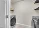Well-equipped laundry room including a front-load washer and dryer with storage shelving at 5234 Tulip Hill Ave, Las Vegas, NV 89141