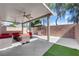 View of the covered outdoor patio area with ample seating, a grill, and ceiling fans at 5234 Tulip Hill Ave, Las Vegas, NV 89141