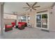 Covered patio with comfortable seating, ceiling fans, and access to the home through sliding glass doors at 5234 Tulip Hill Ave, Las Vegas, NV 89141