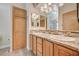 Bathroom featuring a double sink vanity with granite countertops and storage cabinet at 5401 Broadwater Ln, Las Vegas, NV 89130