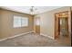 Neutral bedroom features a ceiling fan, double-hung window, and tan colored walls and carpeting at 5401 Broadwater Ln, Las Vegas, NV 89130