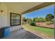 A covered patio offering views of the mature landscaping and green lawn at 5401 Broadwater Ln, Las Vegas, NV 89130