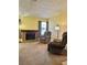 Relaxing living room with brick fireplace, comfortable armchairs, and windows offering natural light and backyard views at 5576 W Rochelle Ave # 27A, Las Vegas, NV 89103