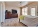 Spacious bedroom with wood-look floors, neutral paint and natural light from the window and door at 5855 Valley Dr # 2106, North Las Vegas, NV 89031