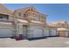 Exterior view of a townhome featuring three garages, a tile roof, and neutral color scheme at 5855 Valley Dr # 2106, North Las Vegas, NV 89031