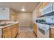 Well-lit kitchen featuring light wood cabinets, tile flooring, and modern white appliances at 5855 Valley Dr # 2106, North Las Vegas, NV 89031