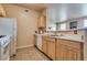 Kitchen view with wood cabinets, a stainless sink, and white appliances at 5855 Valley Dr # 2106, North Las Vegas, NV 89031
