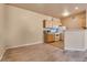 Kitchen with wood cabinets, white appliances, and an open view to the living room area at 5855 Valley Dr # 2106, North Las Vegas, NV 89031