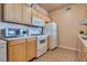 Close-up of the kitchen with wood cabinets, a white range, microwave, and refrigerator at 5855 Valley Dr # 2106, North Las Vegas, NV 89031