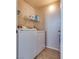 Functional laundry room featuring a side-by-side washer and dryer, with shelving for storage at 5855 Valley Dr # 2106, North Las Vegas, NV 89031