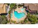 Aerial view of a uniquely shaped community pool, sun loungers, and lush landscaping at 5855 Valley Dr # 2106, North Las Vegas, NV 89031