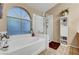 Soaking tub with shower and glass door with tile floors at 5933 Perfect View St, Las Vegas, NV 89130