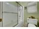 A full bathroom featuring a shower with glass doors, tiled walls, a window, toilet and décor at 5933 Perfect View St, Las Vegas, NV 89130