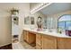 Bright bathroom with dual sinks, wooden cabinets, and decorative accents at 5933 Perfect View St, Las Vegas, NV 89130