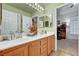 Bright bathroom with a double sink vanity, decorative accents, and view to an adjacent room at 5933 Perfect View St, Las Vegas, NV 89130