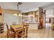 Warm dining area featuring a wooden table set beneath an elegant chandelier and direct access to the kitchen at 5933 Perfect View St, Las Vegas, NV 89130