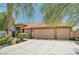 Lovely home featuring a three-car garage, desert landscaping, and shade trees at 5933 Perfect View St, Las Vegas, NV 89130